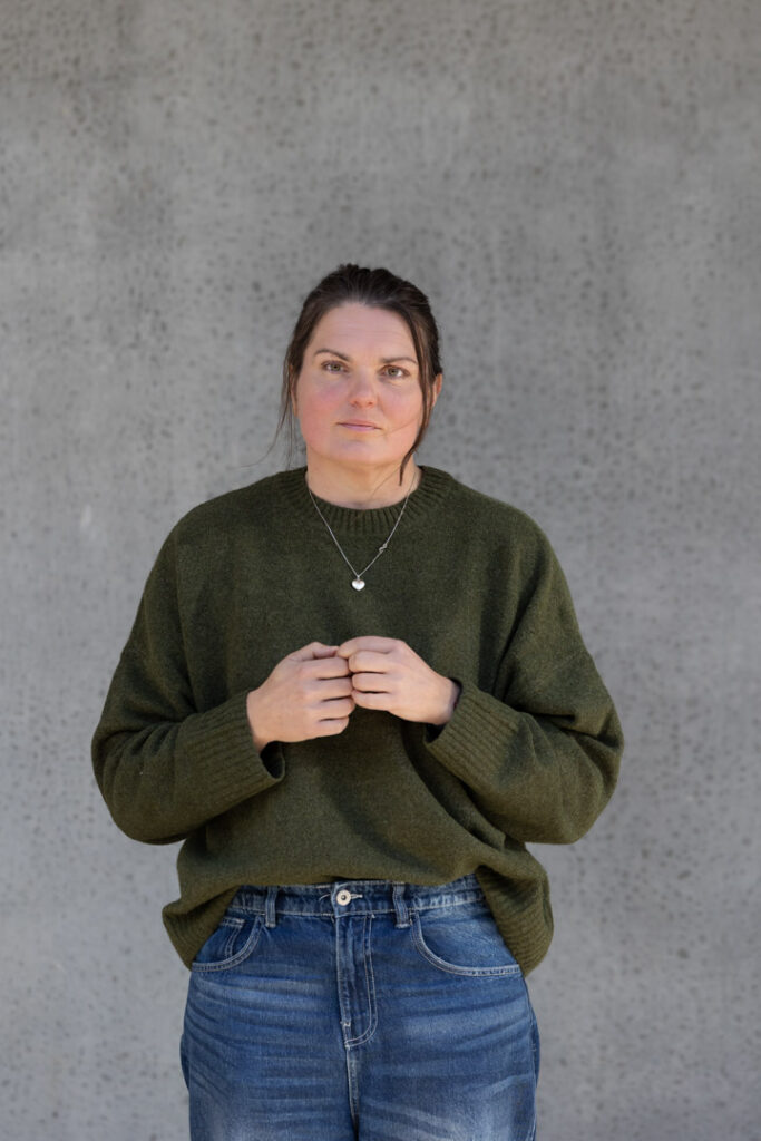 Louise Svendsen står foran en lys betonvæg og ser direkte ind i kameraet
